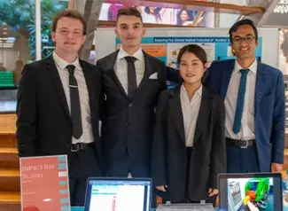 four students showcasing their MIT Impact project